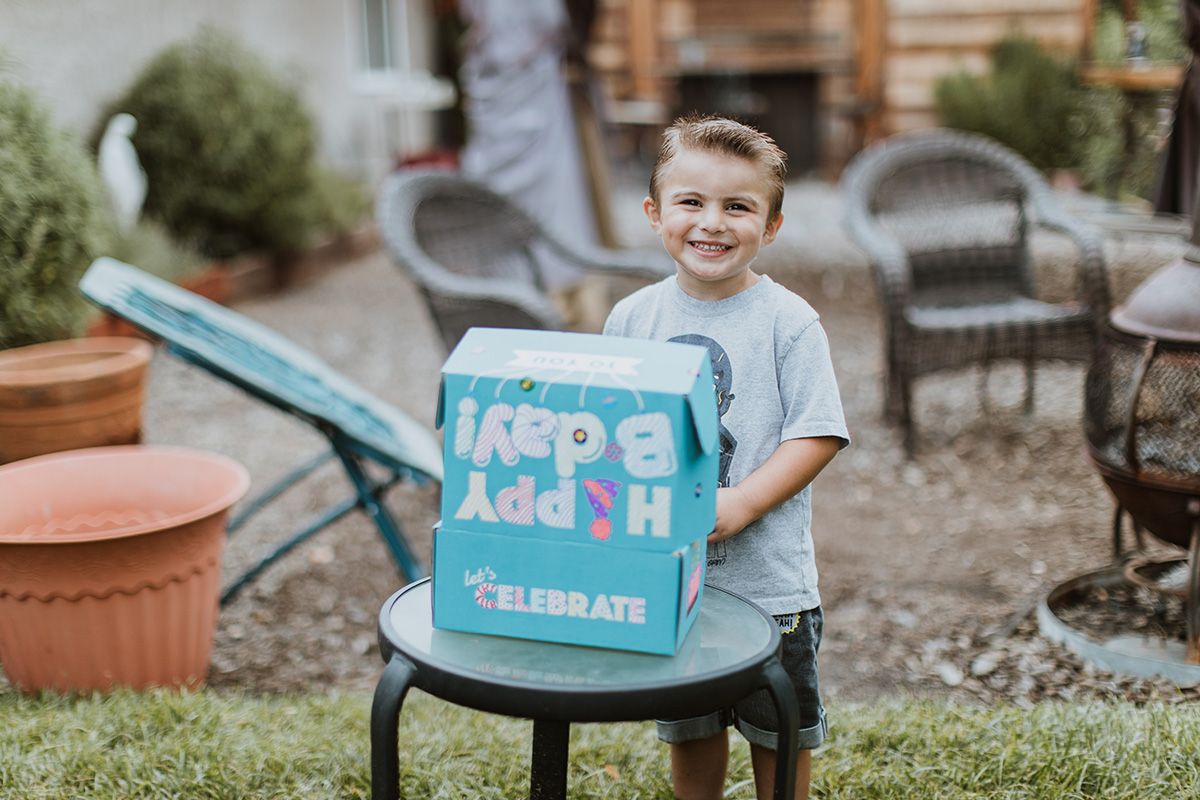 Little kid opening a Birthday box